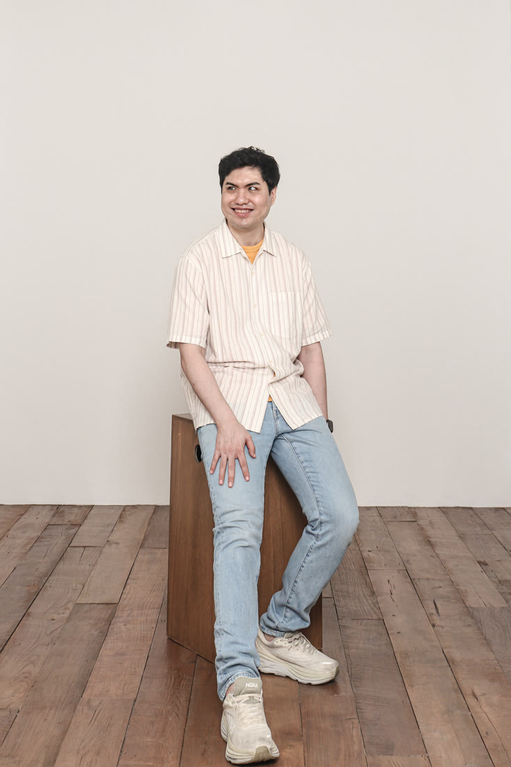 줄무늬 셔츠에 청바지를 입고 나무 상자에 살짝 걸터앉아 환하게 웃는 이창훈