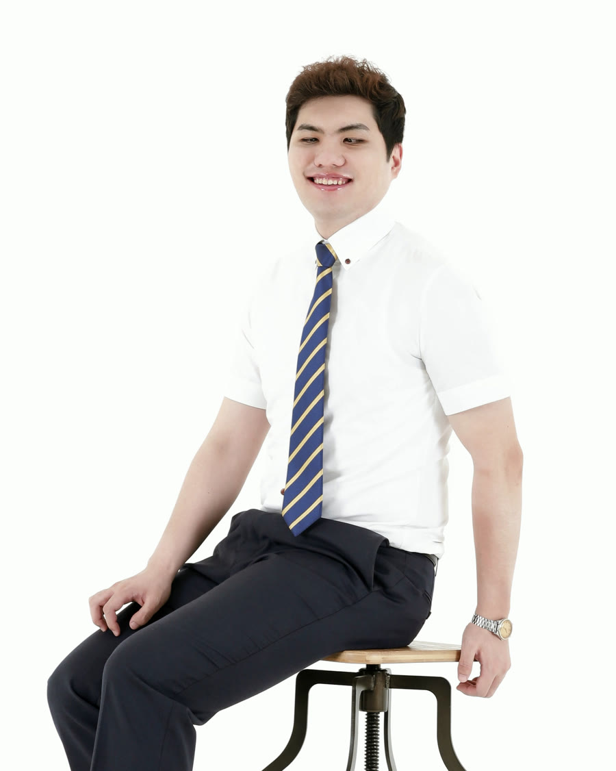 흰 셔츠에 남색 줄무늬 넥타이를 매고 의자에 앉아 환하게 웃는 이창훈